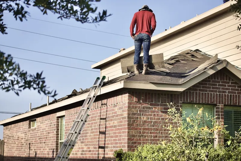 Professional roofer working on a residential roof in Coachlight Village